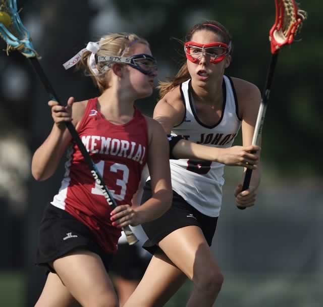 two competing lacrosse players in action